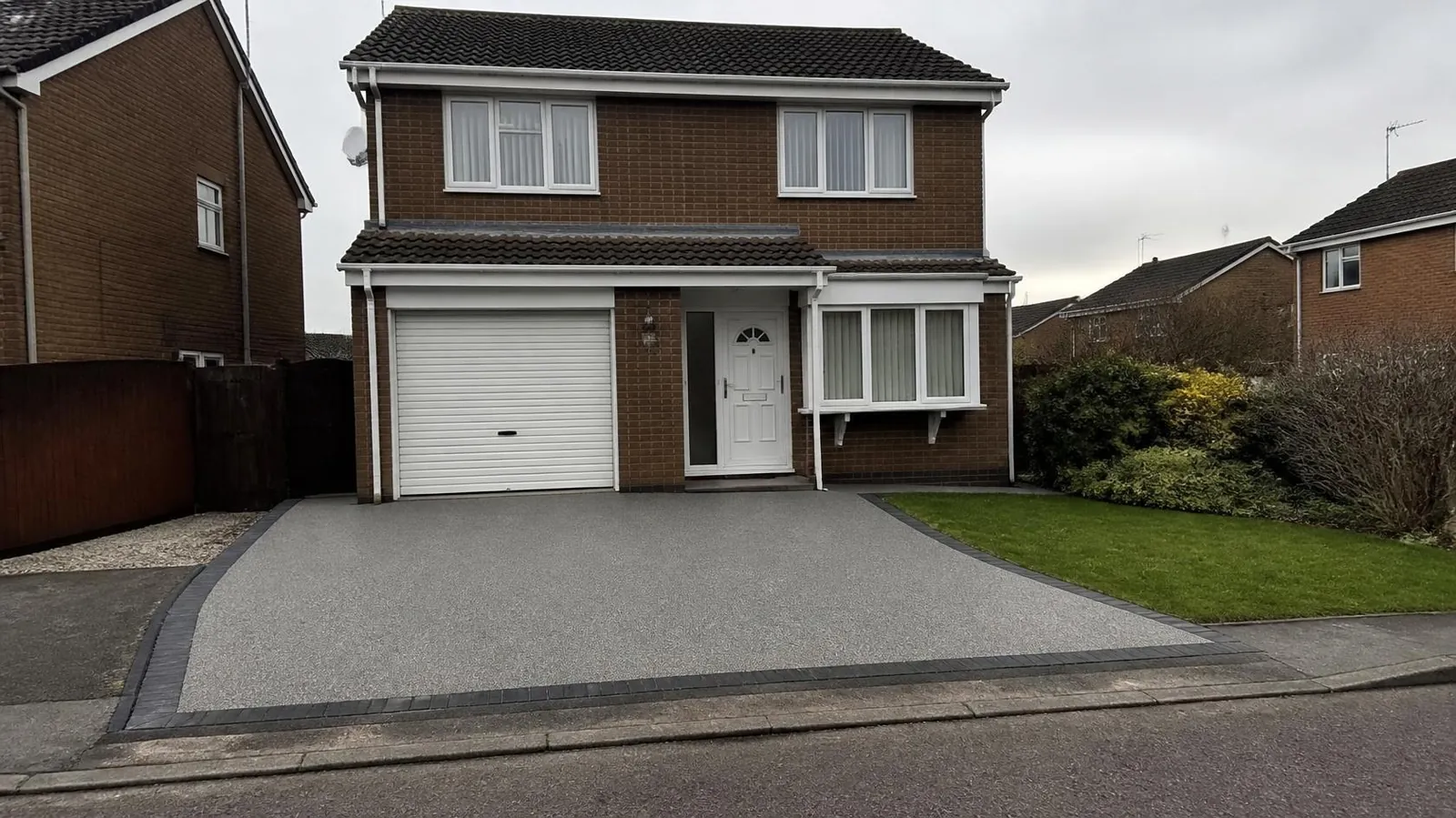 Buff resin-bound driveway leading to the front door of a brick semi