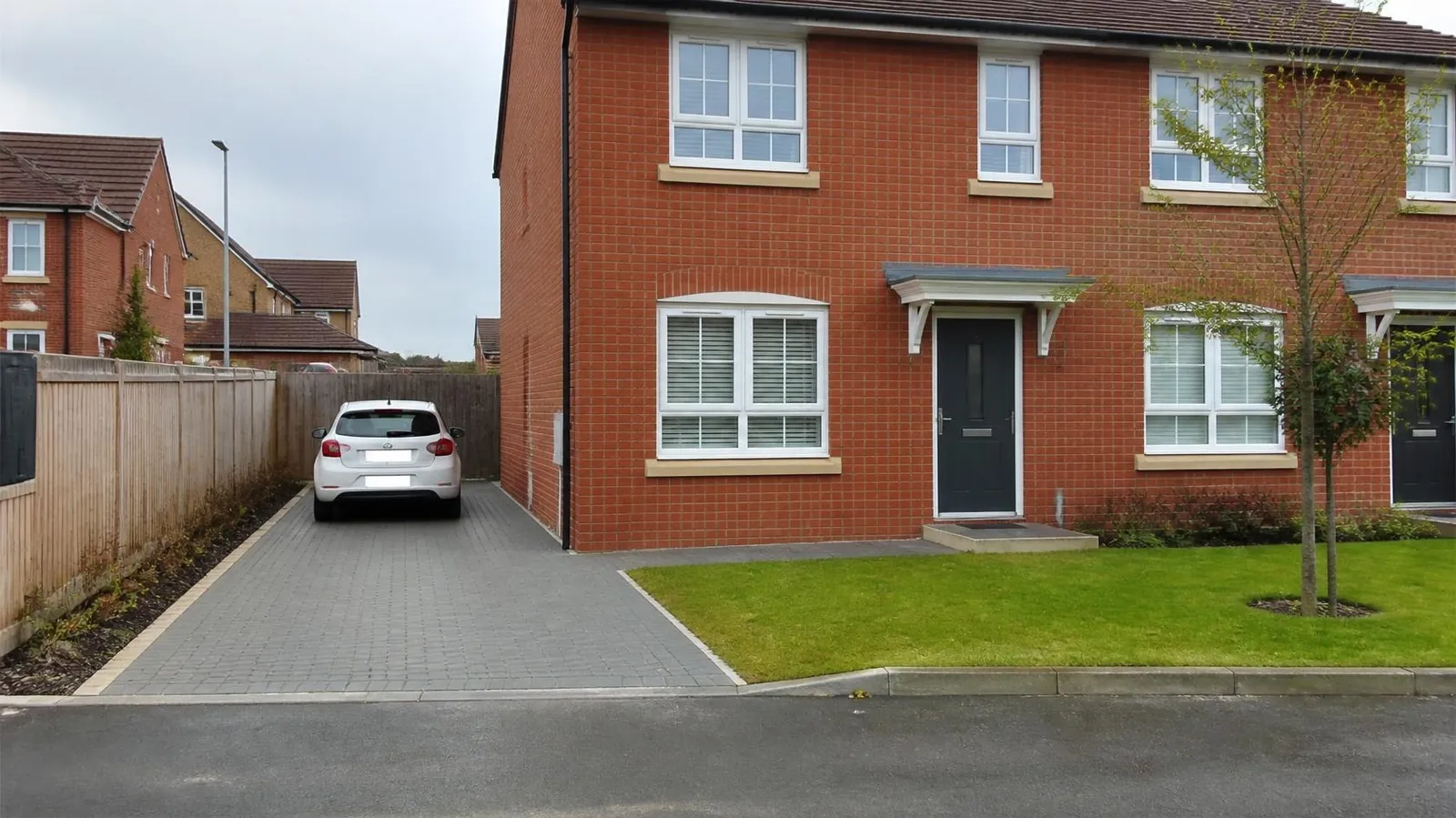 Newer red-brick house with a grey block-paved driveway